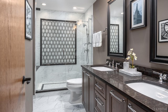 bathroom featuring a tile shower, vanity, and toilet