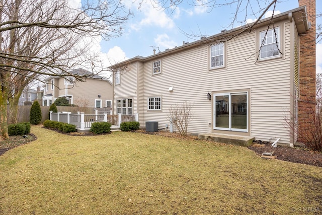 rear view of house featuring central AC unit, a yard, and a deck