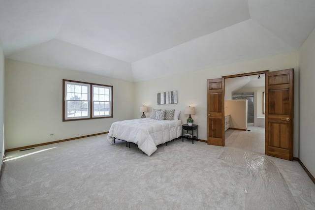 bedroom with vaulted ceiling and light colored carpet