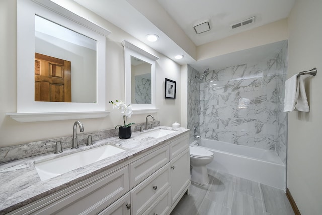 full bathroom featuring tiled shower / bath, vanity, and toilet