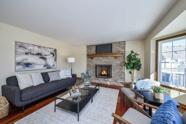 living room featuring a brick fireplace and light wood-type flooring