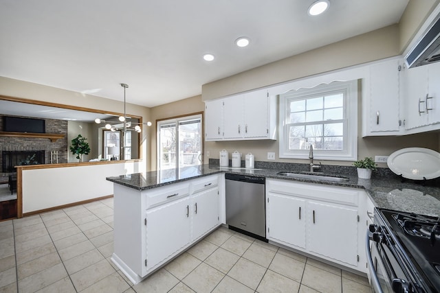 kitchen with sink, kitchen peninsula, pendant lighting, stainless steel appliances, and white cabinets