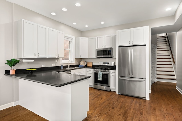 kitchen featuring white cabinetry, dark hardwood / wood-style flooring, stainless steel appliances, and kitchen peninsula