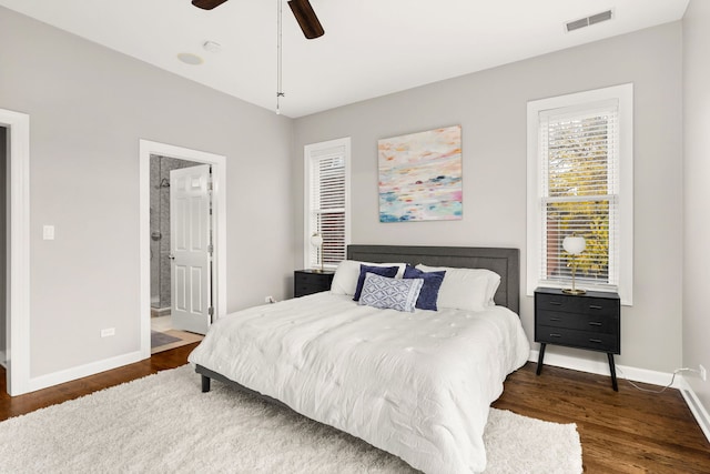 bedroom with ceiling fan, ensuite bath, and dark hardwood / wood-style flooring