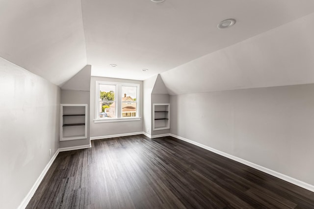 additional living space featuring lofted ceiling and dark hardwood / wood-style floors