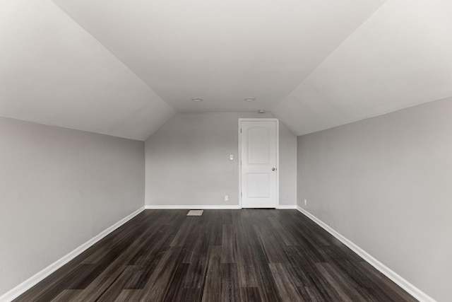 additional living space with lofted ceiling and dark hardwood / wood-style flooring