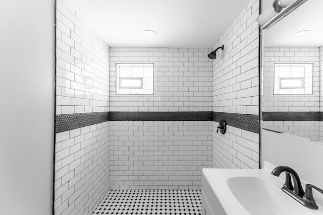 bathroom with a tile shower and sink