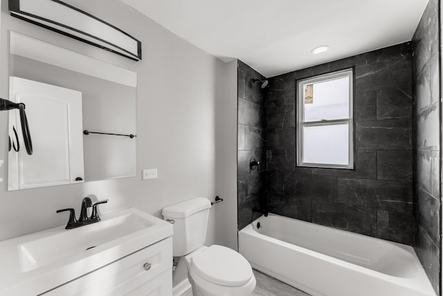 full bathroom with vanity, tiled shower / bath combo, and toilet