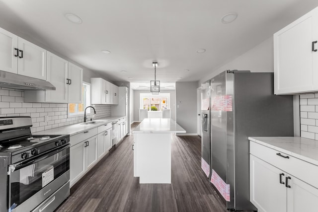 kitchen with white cabinetry, sink, stainless steel appliances, and a kitchen island