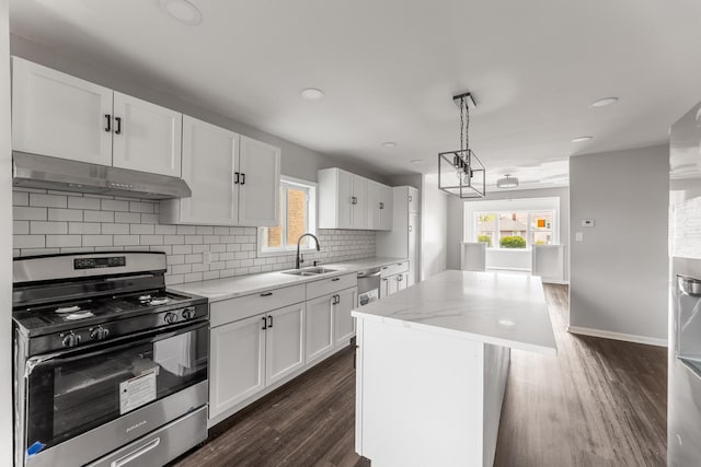 kitchen with sink, hanging light fixtures, stainless steel appliances, a center island, and white cabinets