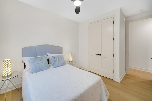 bedroom with ceiling fan, wood-type flooring, and a closet