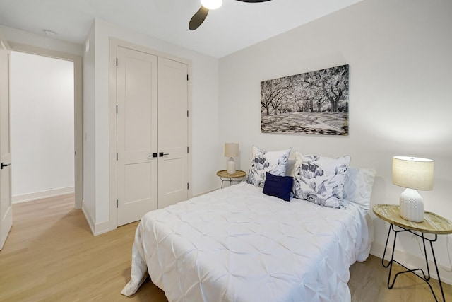 bedroom with a closet, ceiling fan, and light wood-type flooring