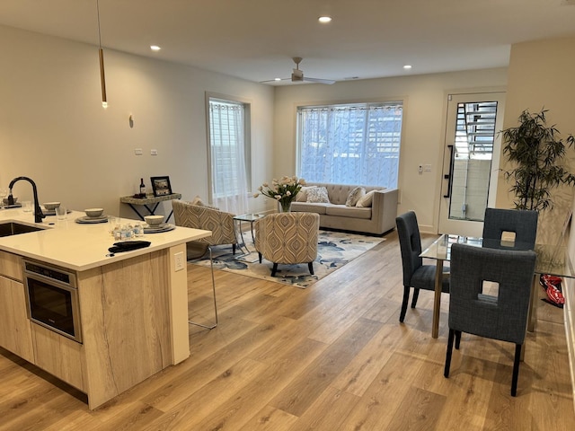 kitchen with sink, a wealth of natural light, light hardwood / wood-style flooring, and light brown cabinets