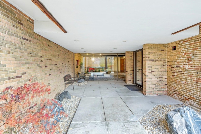 unfurnished living room featuring concrete floors and brick wall