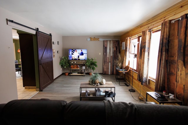 living room with a barn door and light wood-type flooring