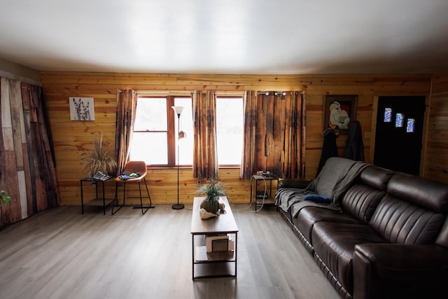 living room with hardwood / wood-style flooring and wood walls