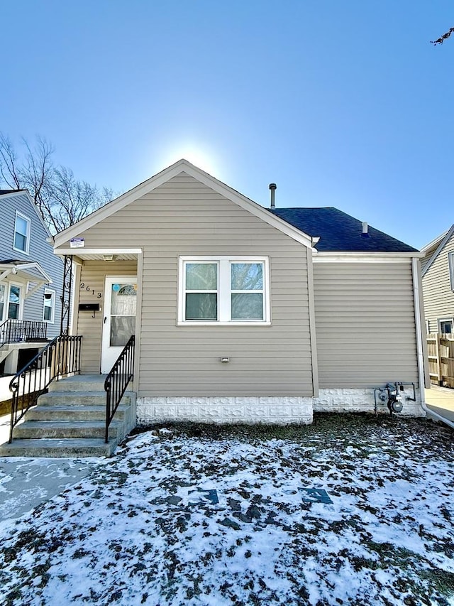 view of snow covered rear of property