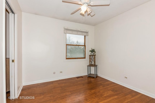 unfurnished room featuring a ceiling fan, dark wood-style flooring, visible vents, and baseboards