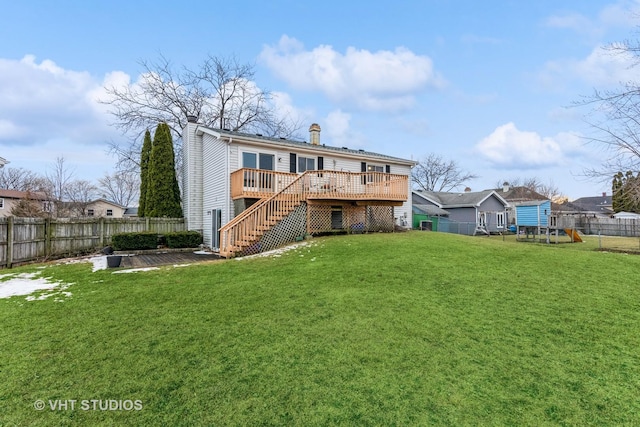 back of property with a fenced backyard, a yard, stairway, a wooden deck, and a chimney