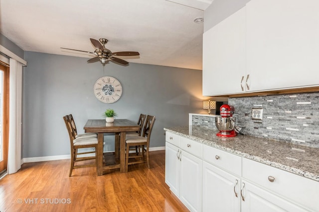 dining room featuring light wood-type flooring, a ceiling fan, and baseboards