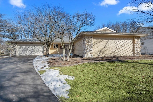 single story home featuring a garage and a front yard