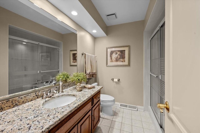 bathroom featuring vanity, walk in shower, tile patterned floors, and toilet