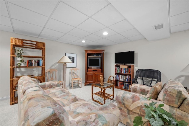 carpeted living room with a drop ceiling