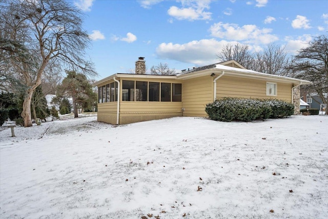 snow covered house with a sunroom