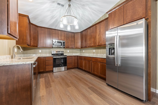 kitchen with sink, light hardwood / wood-style flooring, hanging light fixtures, stainless steel appliances, and light stone countertops