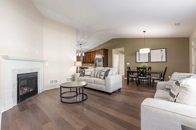 living room featuring a fireplace, vaulted ceiling, and dark hardwood / wood-style floors