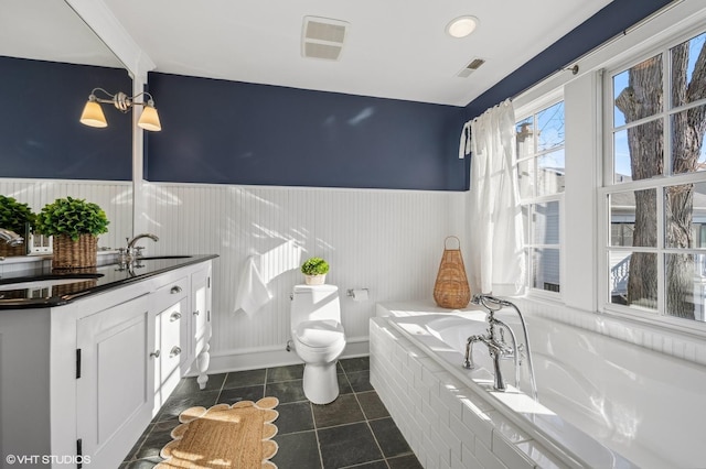 bathroom featuring vanity, a bathing tub, tile patterned floors, and toilet