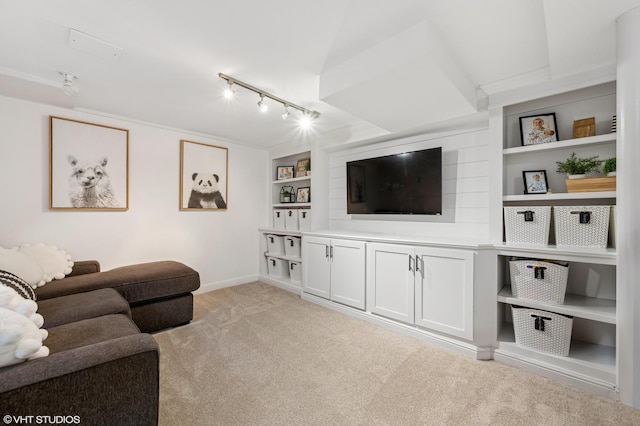 carpeted living room with track lighting and built in shelves