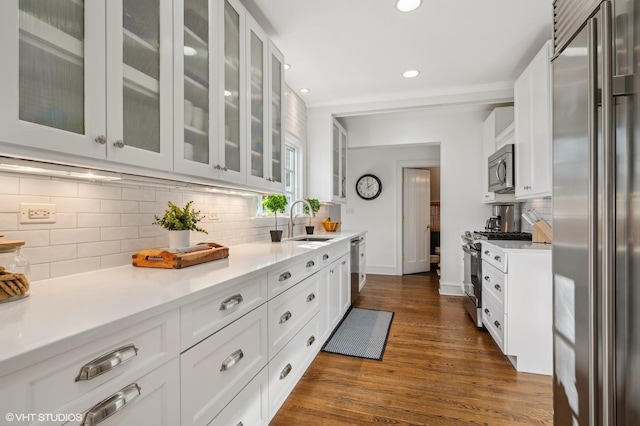 kitchen featuring stainless steel appliances, white cabinetry, sink, and tasteful backsplash