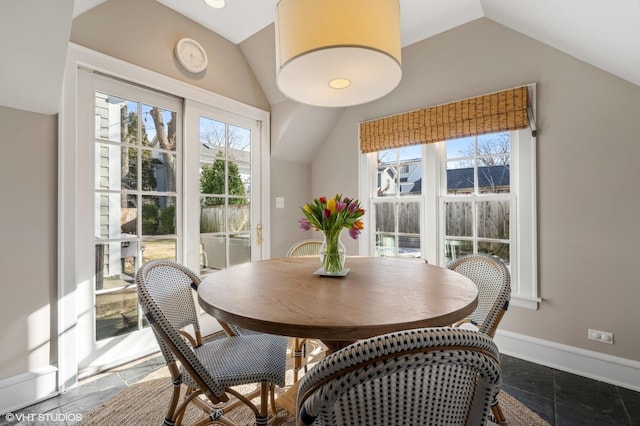 dining room with vaulted ceiling and a healthy amount of sunlight