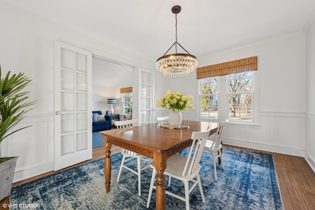 dining room featuring an inviting chandelier, ornamental molding, and dark hardwood / wood-style floors