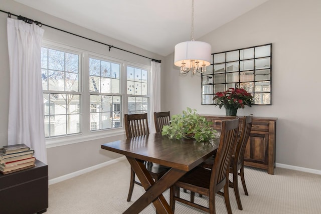 dining room with lofted ceiling, a notable chandelier, and light colored carpet