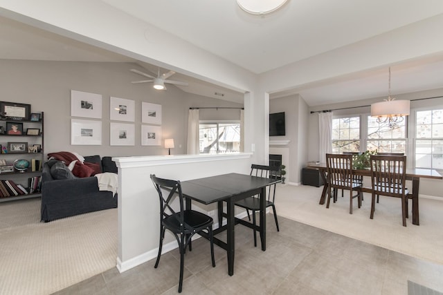 carpeted dining space with vaulted ceiling with beams