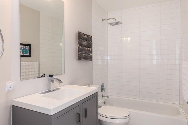 full bathroom with tiled shower / bath, vanity, and toilet