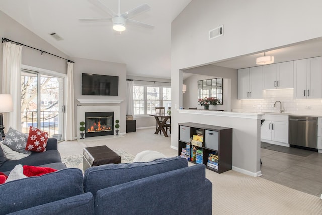 living room with lofted ceiling, sink, light colored carpet, and ceiling fan