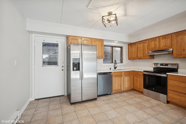 kitchen featuring light tile patterned flooring, appliances with stainless steel finishes, sink, and a textured ceiling