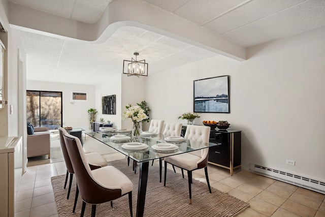 tiled dining space featuring a notable chandelier and baseboard heating