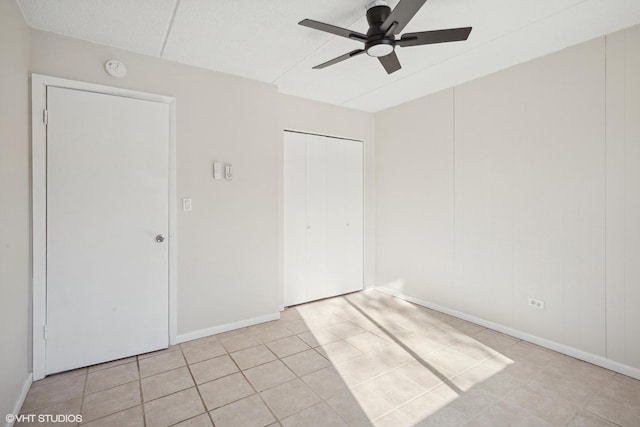 unfurnished bedroom with light tile patterned floors, a closet, and ceiling fan