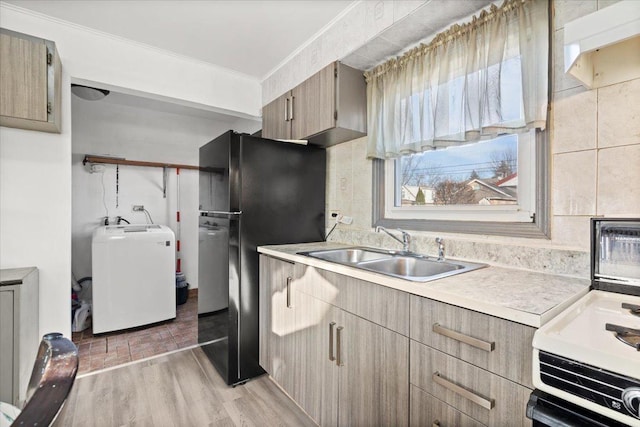 kitchen featuring wood-type flooring, sink, range, crown molding, and black fridge