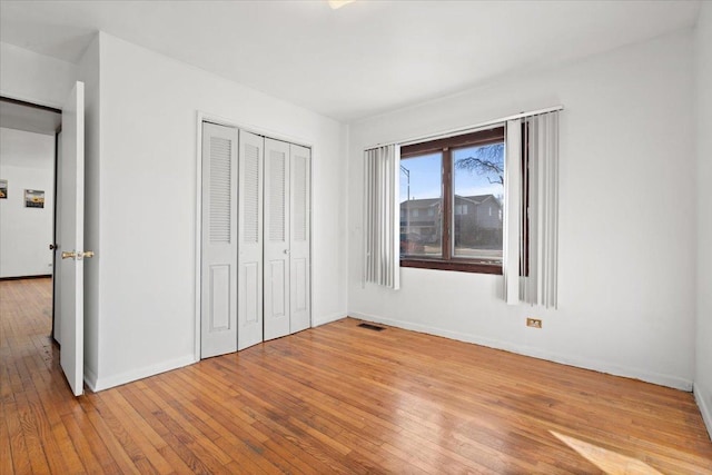 unfurnished bedroom featuring light hardwood / wood-style flooring and a closet