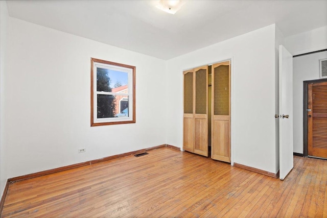 unfurnished bedroom with a closet and light wood-type flooring