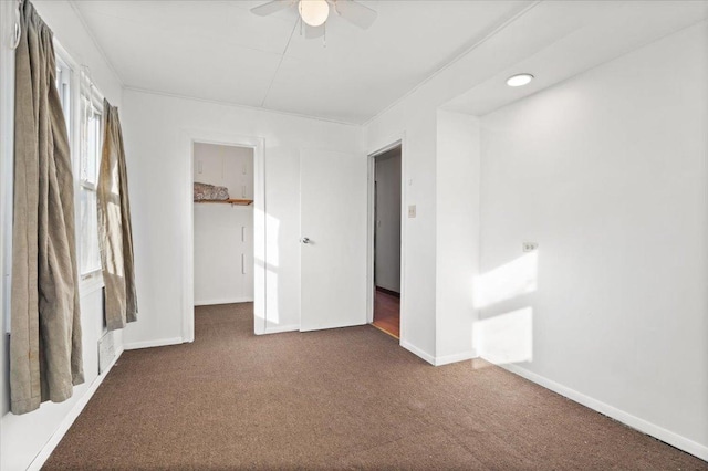 unfurnished bedroom featuring dark carpet, ceiling fan, and a closet