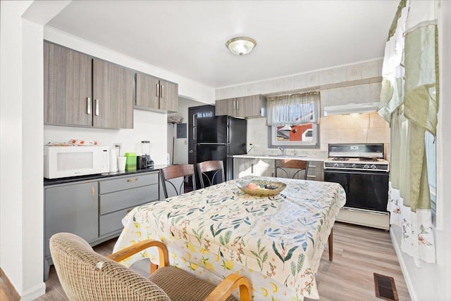 kitchen with white appliances and light hardwood / wood-style floors