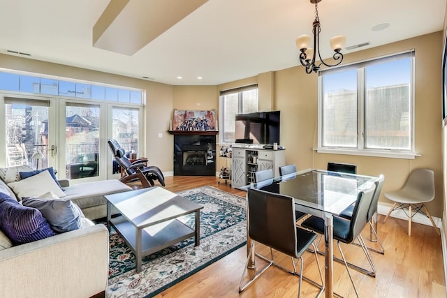 living room featuring a notable chandelier and light wood-type flooring