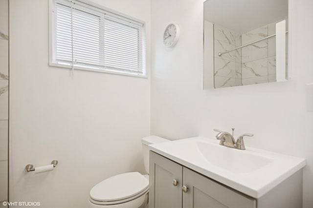 full bathroom featuring a marble finish shower, toilet, and vanity