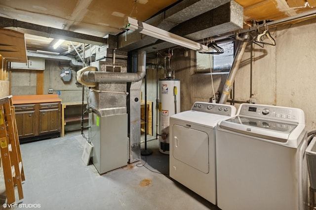 laundry room with heating unit, washer and clothes dryer, water heater, and laundry area